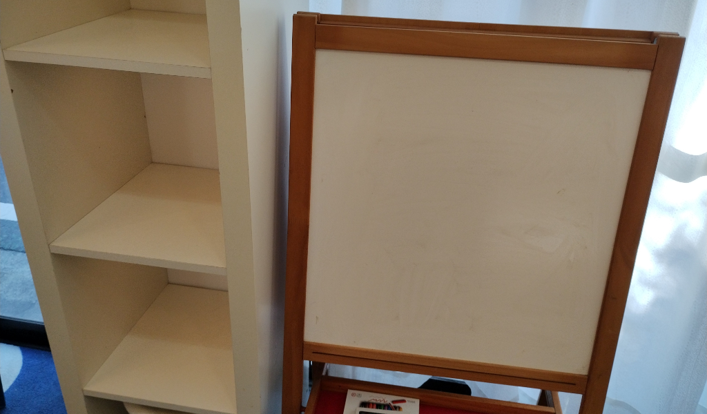 背の高い棚の隣は古めかしい落書きボード